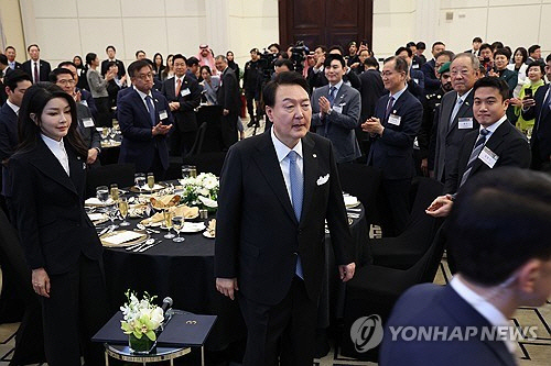 사우디아라비아를 국빈 방문 중인 윤석열 대통령과 김건희 여사가 23일(현지시간) 리야드의 메리어트 호텔에서 열린 동행 경제인 만찬에 입장하며 경제인들의 박수를 받고 있다.  [리야드=연합뉴스]